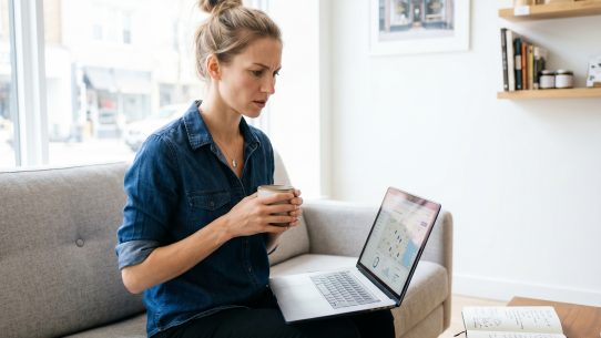 Femme travaillant sur ordinateur portable avec café