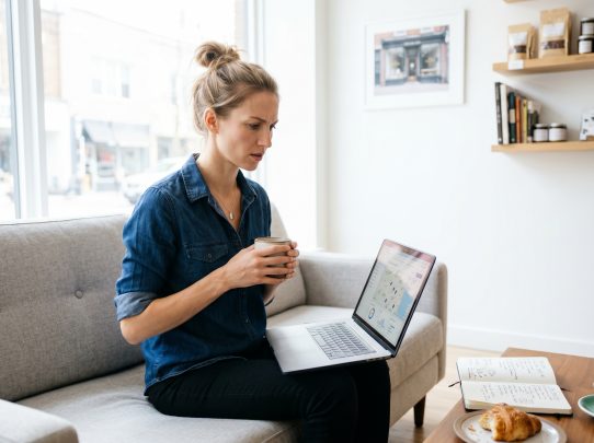 Femme travaillant sur ordinateur portable avec café