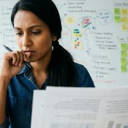 Professionnelle concentrée analysant des objectifs SEO devant un tableau de planification stratégique