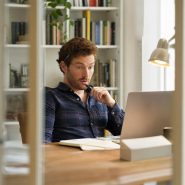 Homme surpris devant ordinateur portable au bureau
