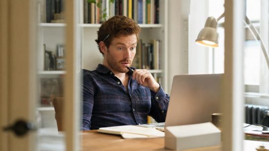 Homme surpris devant ordinateur portable au bureau