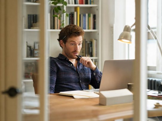 Homme surpris devant ordinateur portable au bureau