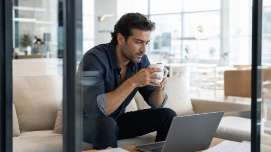 Homme travaillant sur ordinateur portable avec café